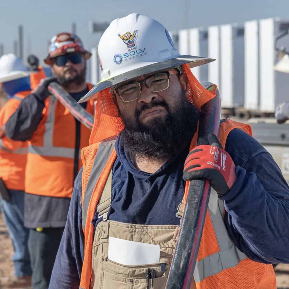 Electrician Trainee on a jobsite carring a cable.
