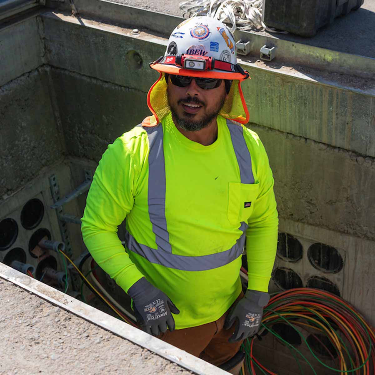 Electrician working in an underground junction box.