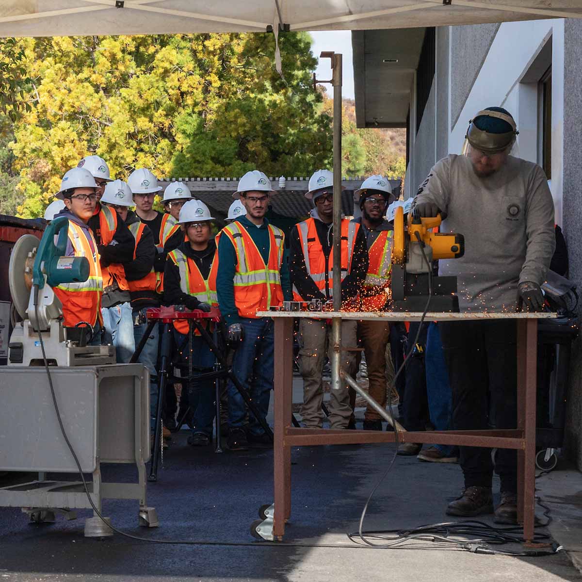 Instructor showing Electrician Trainees how to use a chop saw.