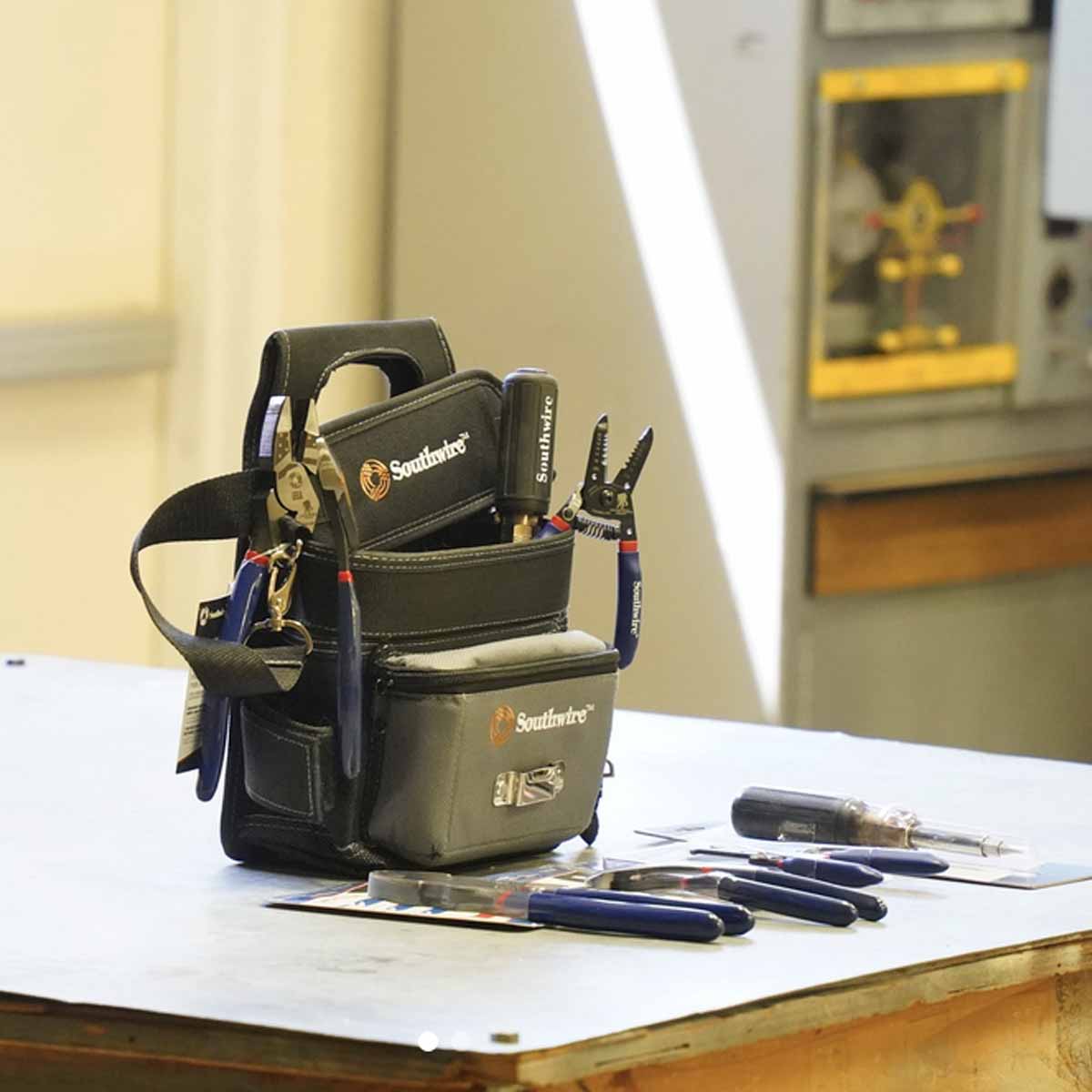 Electrician tools in a tool holder and also on a table