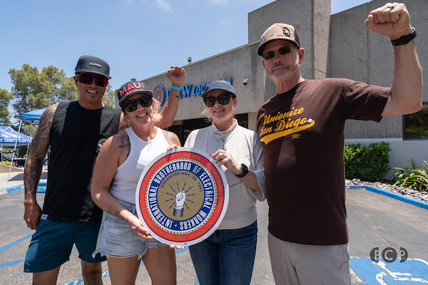 our people posing for a photo holding up a larger IBEW logo.
